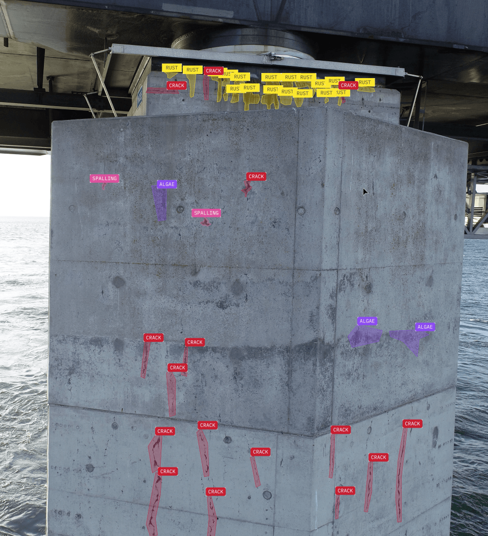 Photograph of a bridge support annotated by computer-generated flags that say crack, algae, spalling, and rust